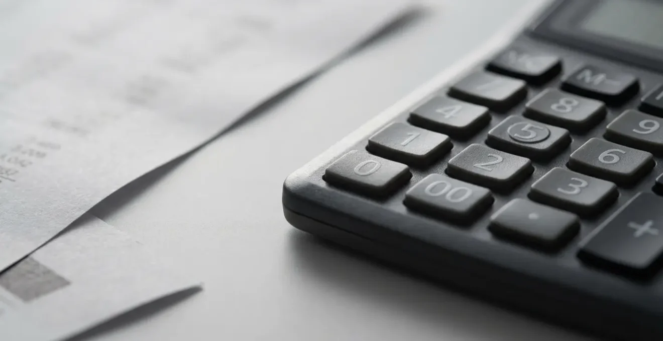 Documents comptables et calculatrice sur bureau avec analyse de charges locatives